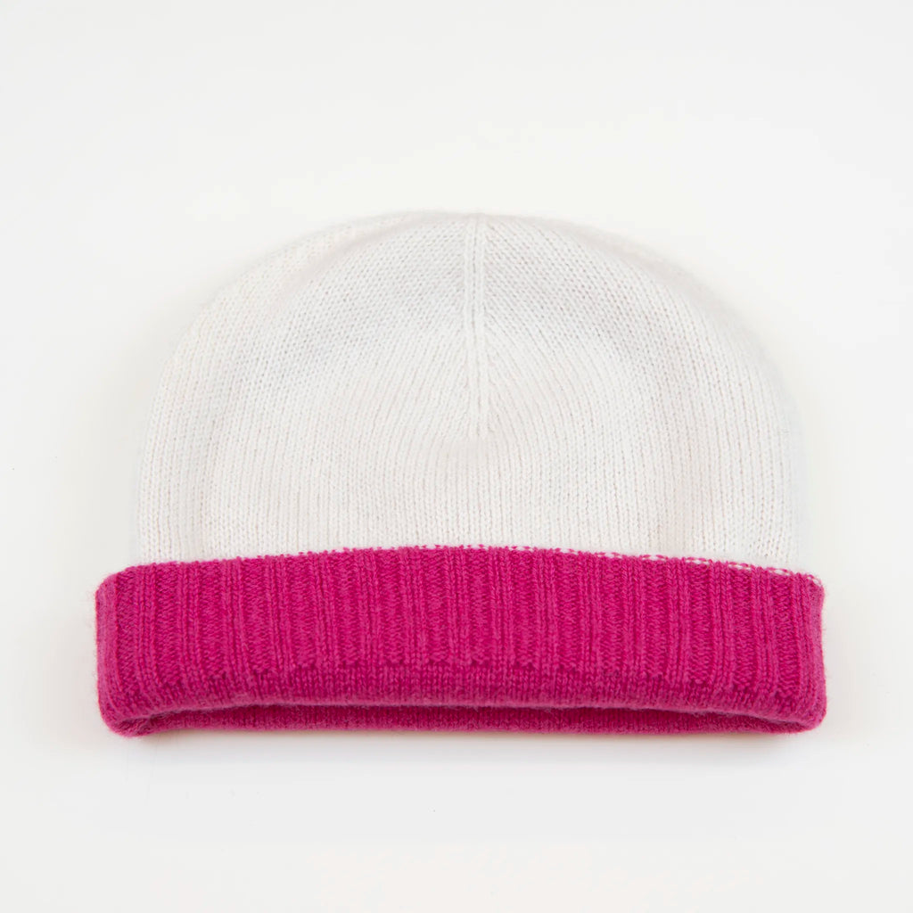 Cuffia doubleface fucsia e panna in 100% Cashmere, Made in Italy. Pratica e versatile, può essere indossata con o senza risvolto. Trama rasata e pregiata manifattura per una vestibilità confortevole e di qualità.