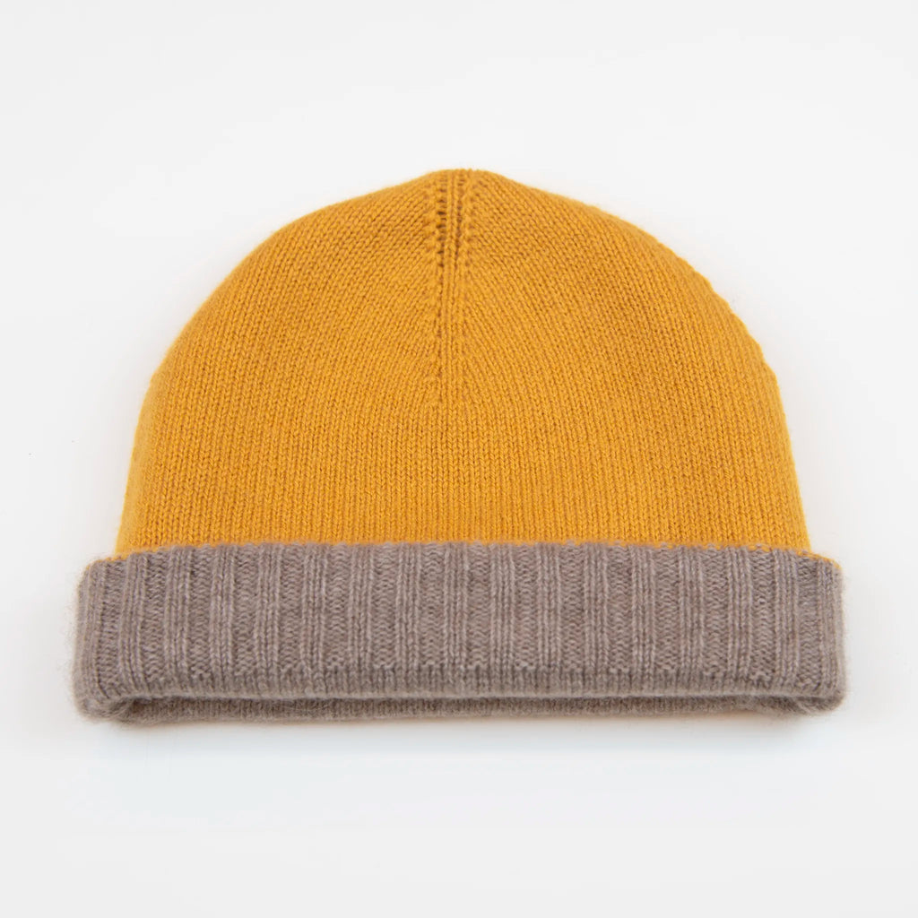 Cuffia doubleface giallo e marrone in 100% Cashmere, Made in Italy. Pratica e versatile, può essere indossata con o senza risvolto. Trama rasata e pregiata manifattura per una vestibilità confortevole e di qualità.