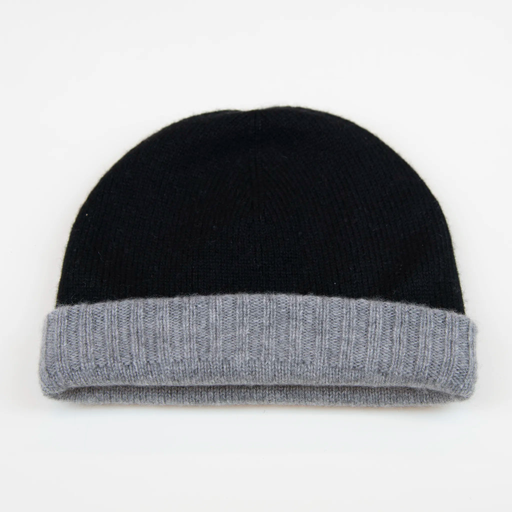 Cuffia doubleface grigio e nero in 100% Cashmere, Made in Italy. Pratica e versatile, può essere indossata con o senza risvolto. Trama rasata e pregiata manifattura per una vestibilità confortevole e di qualità.