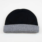 Cuffia doubleface grigio e nero in 100% Cashmere, Made in Italy. Pratica e versatile, può essere indossata con o senza risvolto. Trama rasata e pregiata manifattura per una vestibilità confortevole e di qualità.