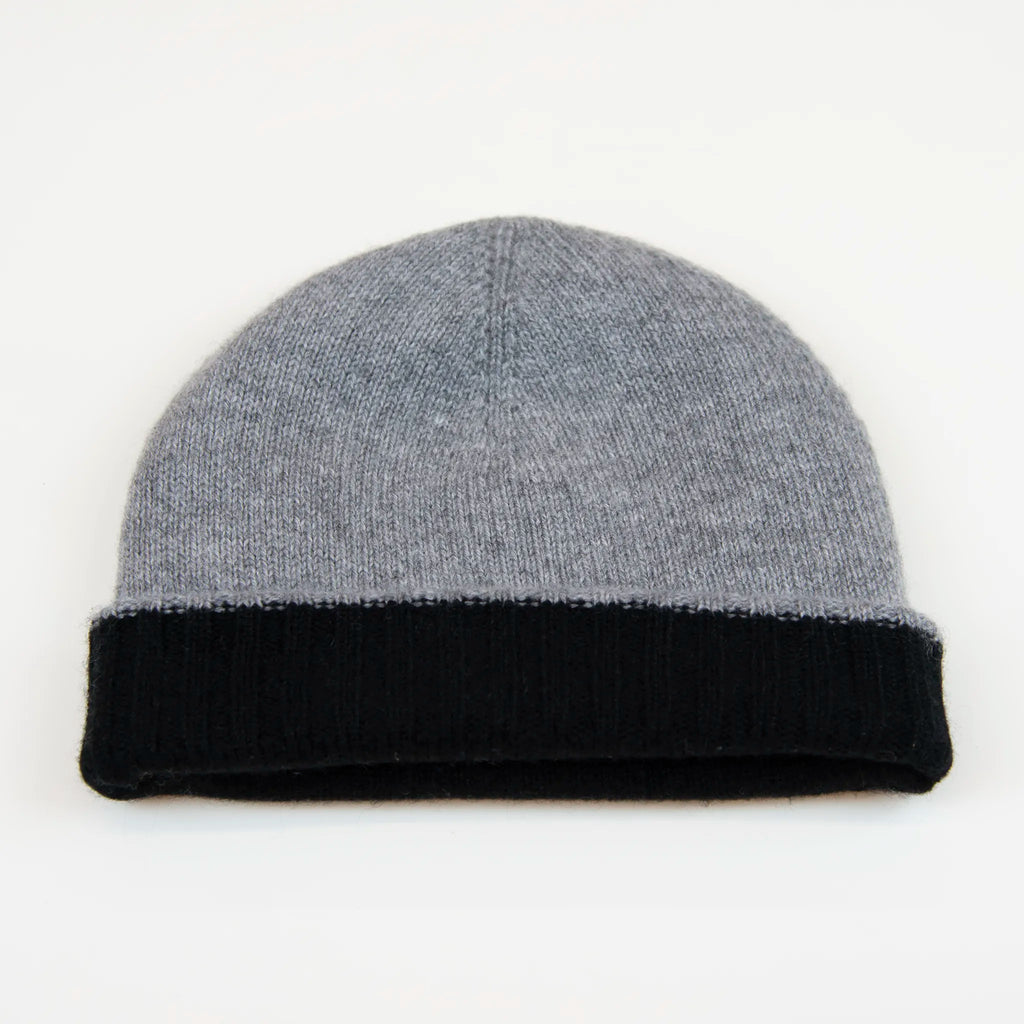 Cuffia doubleface grigio e nero in 100% Cashmere, Made in Italy. Pratica e versatile, può essere indossata con o senza risvolto. Trama rasata e pregiata manifattura per una vestibilità confortevole e di qualità.