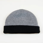 Cuffia doubleface grigio e nero in 100% Cashmere, Made in Italy. Pratica e versatile, può essere indossata con o senza risvolto. Trama rasata e pregiata manifattura per una vestibilità confortevole e di qualità.