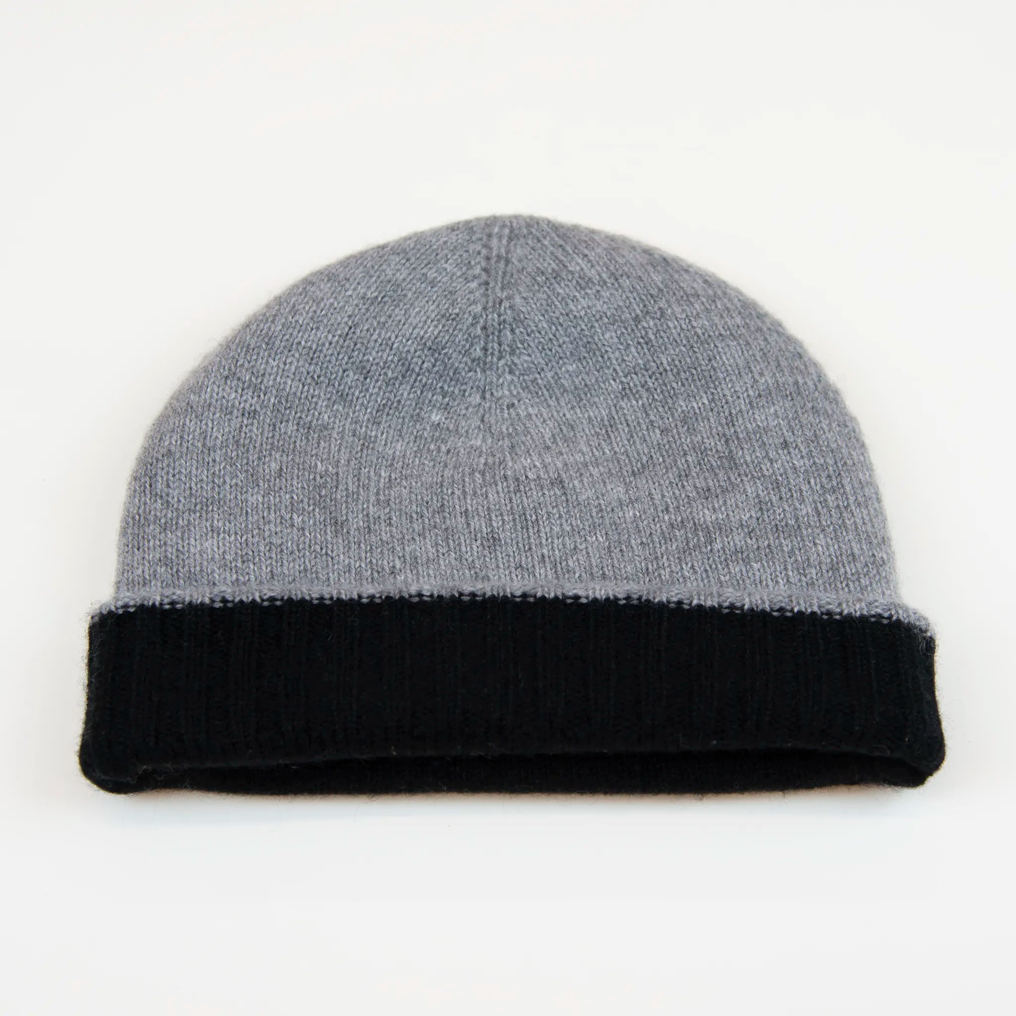 Cuffia doubleface grigio e nero in 100% Cashmere, Made in Italy. Pratica e versatile, può essere indossata con o senza risvolto. Trama rasata e pregiata manifattura per una vestibilità confortevole e di qualità.