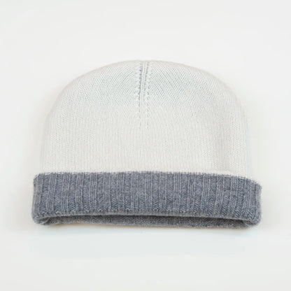 Cuffia doubleface grigio e panna in 100% Cashmere, Made in Italy. Pratica e versatile, può essere indossata con o senza risvolto. Trama rasata e pregiata manifattura per una vestibilità confortevole e di qualità.