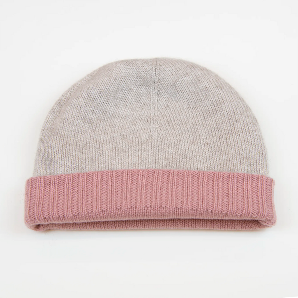 Cuffia doubleface rosa e panna in 100% Cashmere, Made in Italy. Pratica e versatile, può essere indossata con o senza risvolto. Trama rasata e pregiata manifattura per una vestibilità confortevole e di qualità.