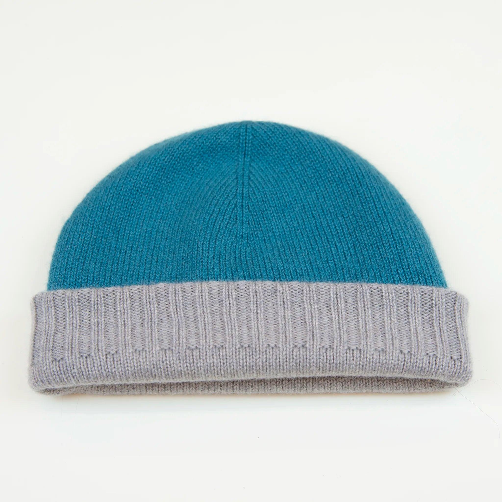 Cuffia doubleface celeste e grigio in 100% Cashmere, Made in Italy. Pratica e versatile, può essere indossata con o senza risvolto. Trama rasata e pregiata manifattura per una vestibilità confortevole e di qualità.