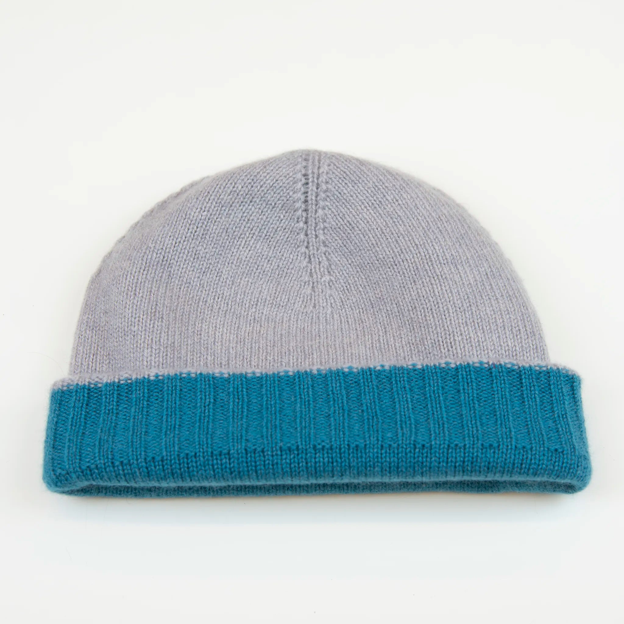 Cuffia doubleface celeste e grigio in 100% Cashmere, Made in Italy. Pratica e versatile, può essere indossata con o senza risvolto. Trama rasata e pregiata manifattura per una vestibilità confortevole e di qualità.