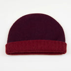 Cuffia doubleface rosso e prugna in 100% Cashmere, Made in Italy. Pratica e versatile, può essere indossata con o senza risvolto. Trama rasata e pregiata manifattura per una vestibilità confortevole e di qualità.