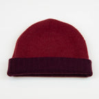 Cuffia doubleface rosso e prugna in 100% Cashmere, Made in Italy. Pratica e versatile, può essere indossata con o senza risvolto. Trama rasata e pregiata manifattura per una vestibilità confortevole e di qualità.