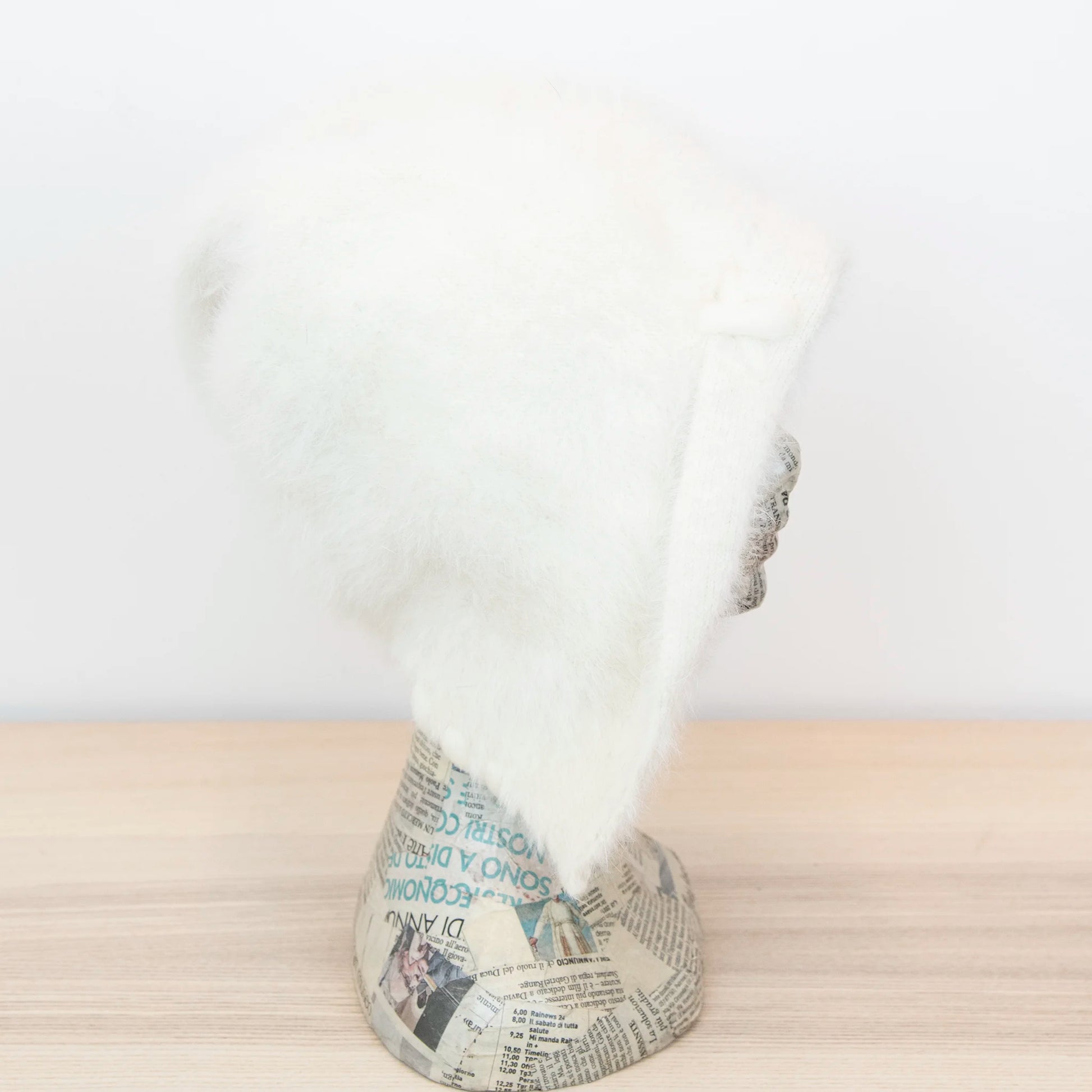 Cuffia in angora beige, soffice e confortevole, realizzata con pregiata manifattura Made in Italy. Il design richiama lo stile tipicamente nord-europeo, unendo eleganza e calore.