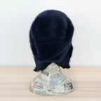 Cuffia in angora blu, soffice e confortevole, realizzata con pregiata manifattura Made in Italy. Il design richiama lo stile tipicamente nord-europeo, unendo eleganza e calore.
