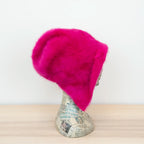 Cuffia in angora fucsia, soffice e confortevole, realizzata con pregiata manifattura Made in Italy. Il design richiama lo stile tipicamente nord-europeo, unendo eleganza e calore.