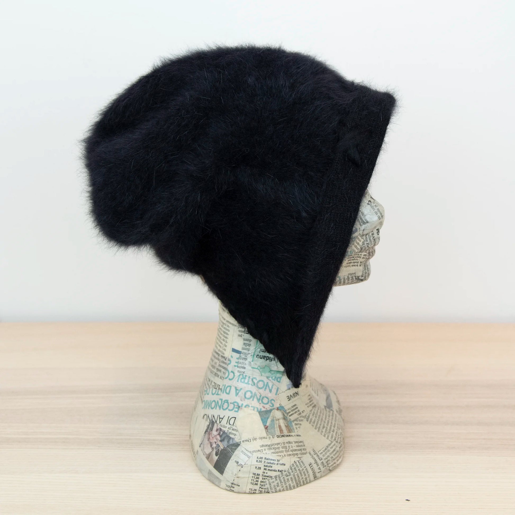 Cuffia in angora nero, soffice e confortevole, realizzata con pregiata manifattura Made in Italy. Il design richiama lo stile tipicamente nord-europeo, unendo eleganza e calore.
