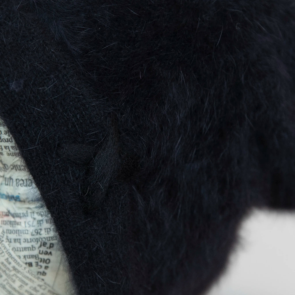 Cuffia in angora nero, soffice e confortevole, realizzata con pregiata manifattura Made in Italy. Il design richiama lo stile tipicamente nord-europeo, unendo eleganza e calore.