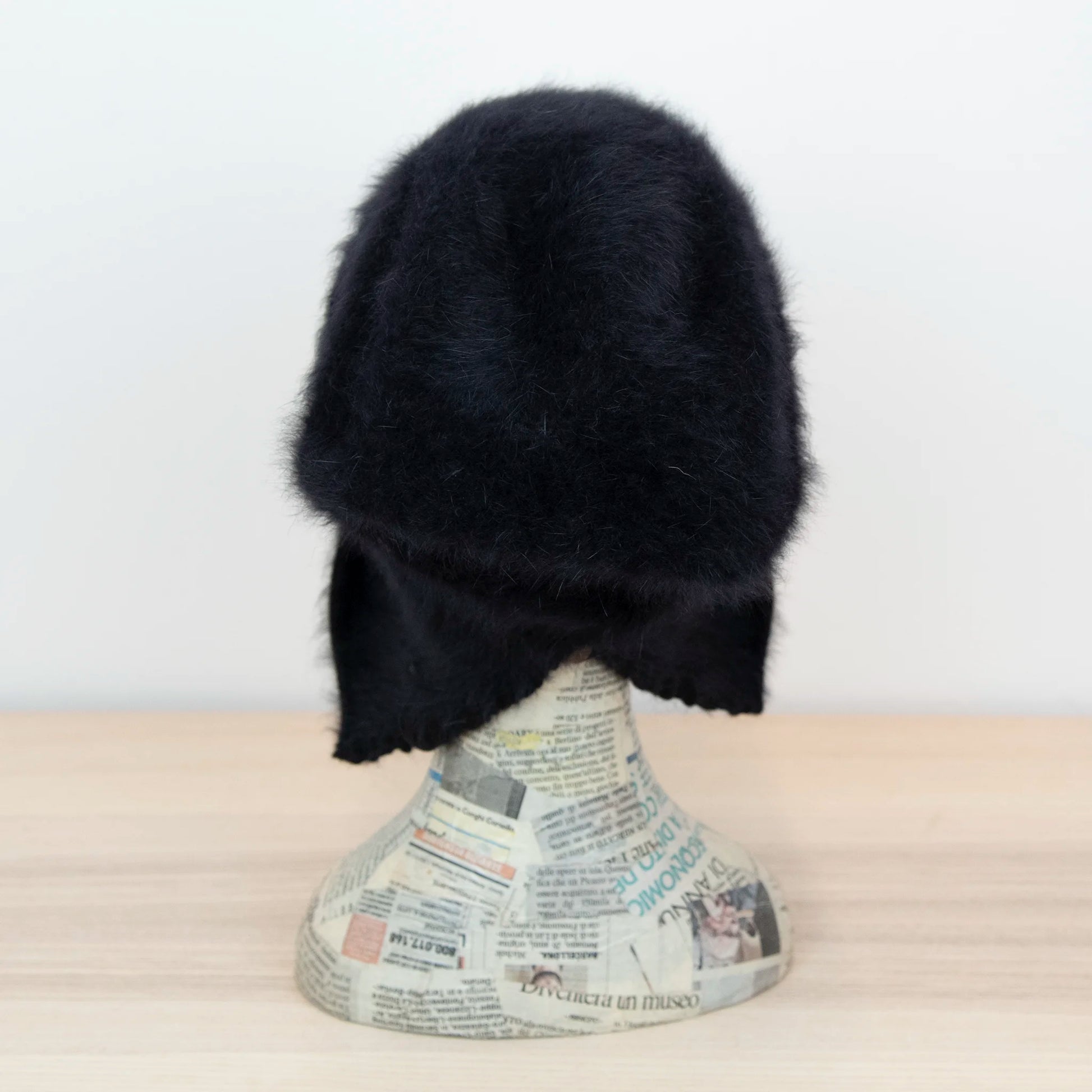 Cuffia in angora nero, soffice e confortevole, realizzata con pregiata manifattura Made in Italy. Il design richiama lo stile tipicamente nord-europeo, unendo eleganza e calore.