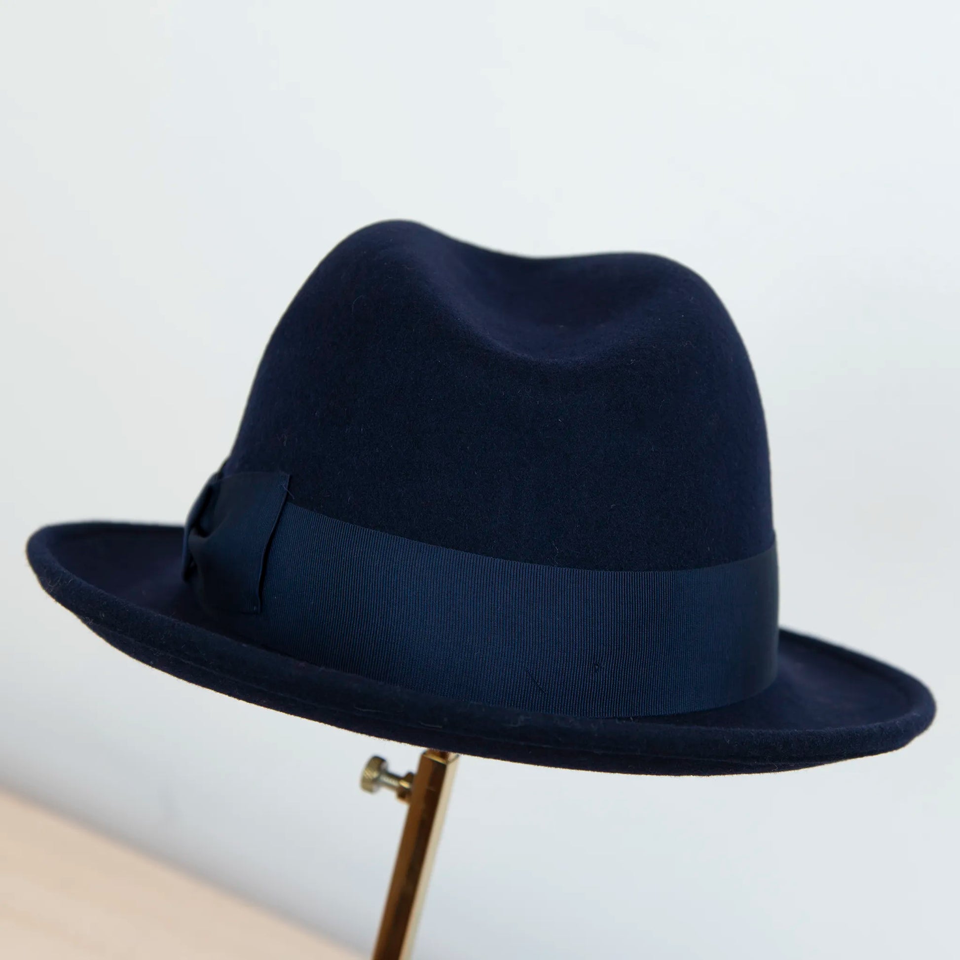Cappello in feltro di lana blu, Made in Italy, ispirato a Humphrey Bogart. Falda media 5,5 cm rialzata sul retro, cupola 11,5 cm, cinta in gros-grain 4 cm blu. Eleganza senza tempo.