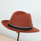 Cappello in 100% feltro di lana, color coccio (terra bruciata), ispirato a Humphrey Bogart, falda media 5,5 cm rialzata sul retro, cupola 11,5 cm, cinta a contrasto, manifattura italiana.