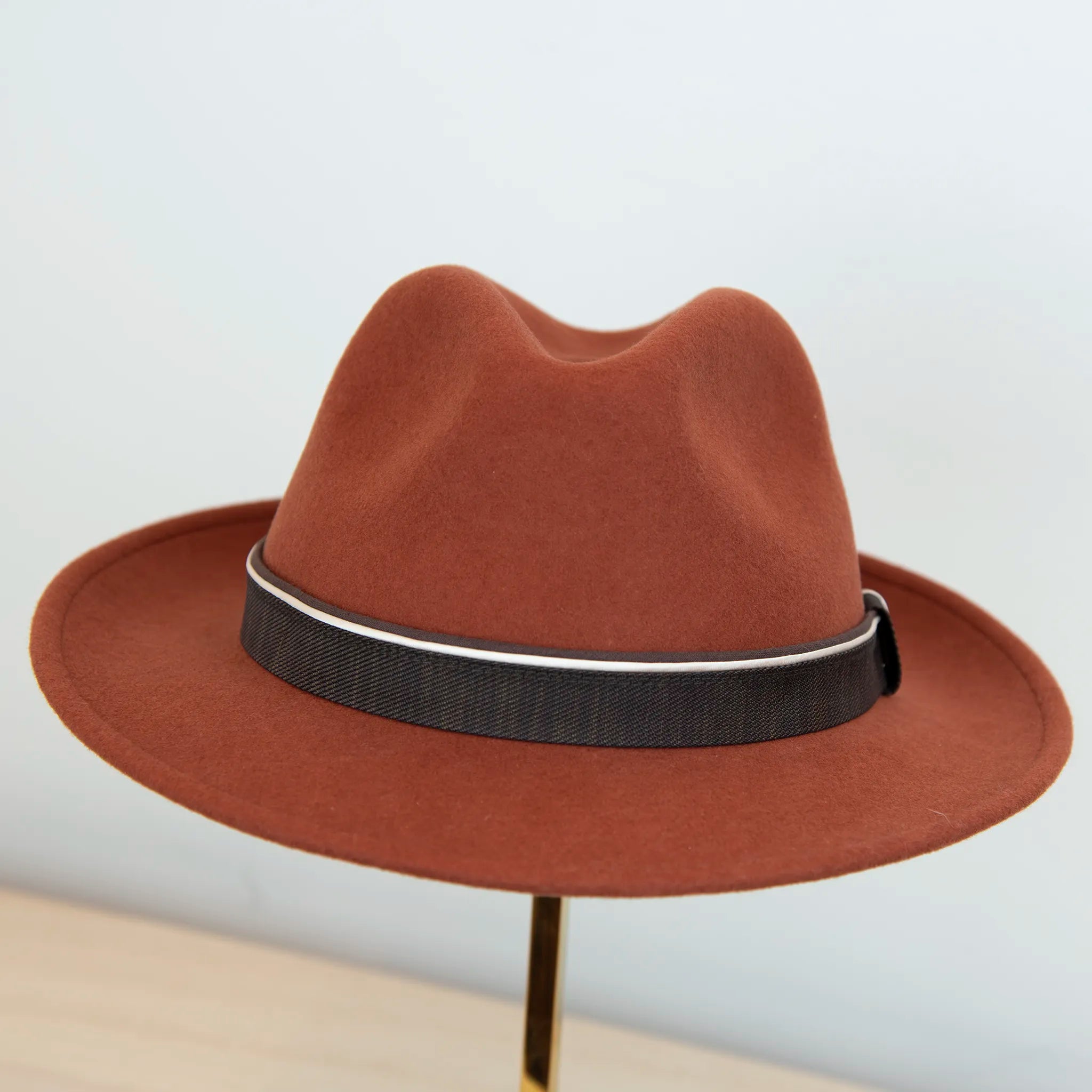 Cappello in 100% feltro di lana, color coccio (terra bruciata), ispirato a Humphrey Bogart, falda media 5,5 cm rialzata sul retro, cupola 11,5 cm, cinta a contrasto, manifattura italiana.