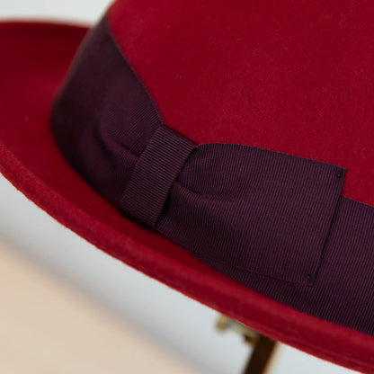 Dettaglio cinta e tessuto del cappello in feltro di lana Rosso, Made in Italy, falda corta 5 cm e cinta in gros-grain viola. Parte della Collezione Emporio San Felice, elegante e versatile per ogni occasione.