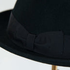 Dettaglio cinta e tessuto del cappello in feltro di lana nero, Made in Italy, falda corta 5 cm e cinta in gros-grain nera. Parte della Collezione Emporio San Felice, elegante e versatile per ogni occasione.