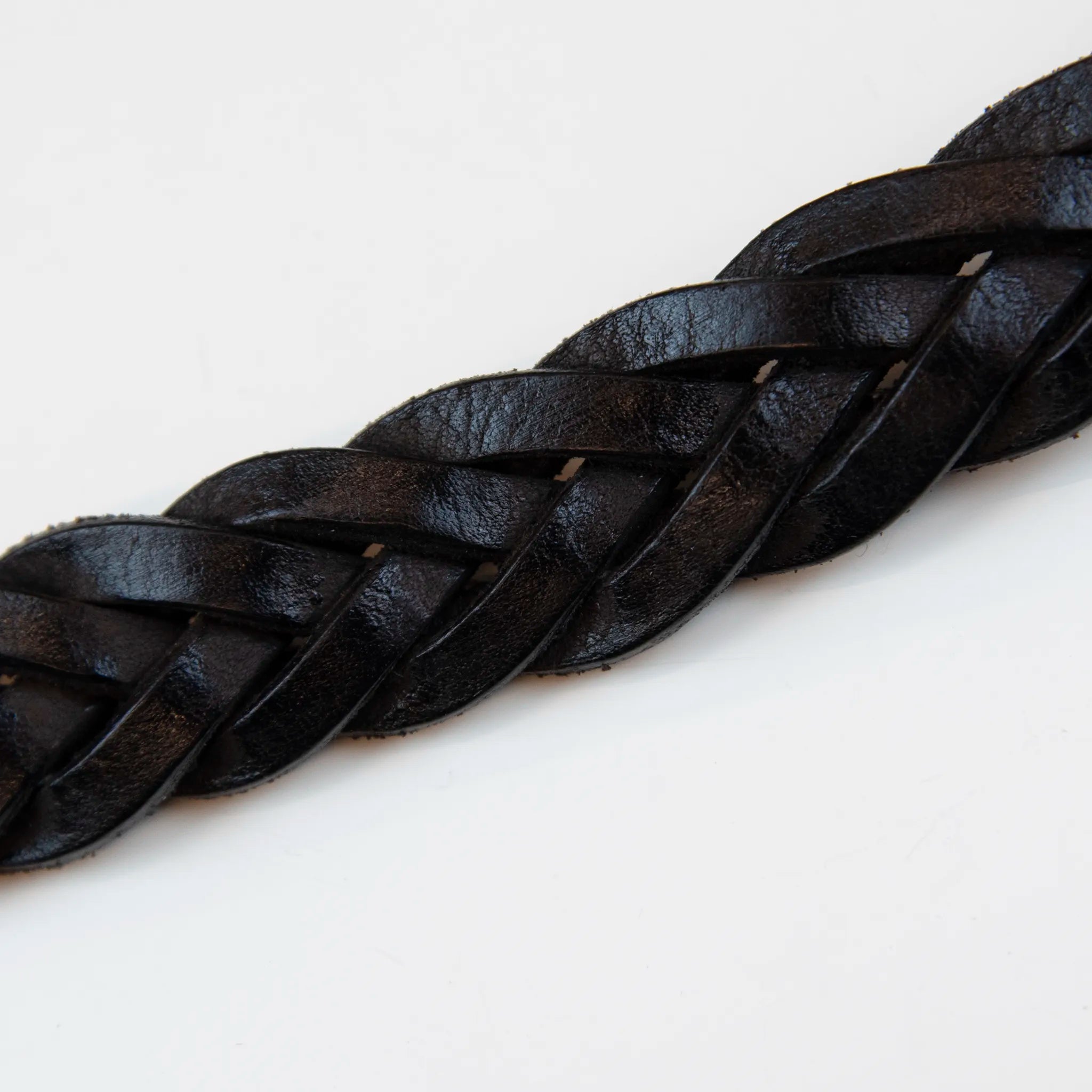 Cintura in pelle marrone intrecciata con fibbia intarsiata, realizzata con materiali di pregio, Made in Italy, progettata per garantire durata e resistenza nel tempo.