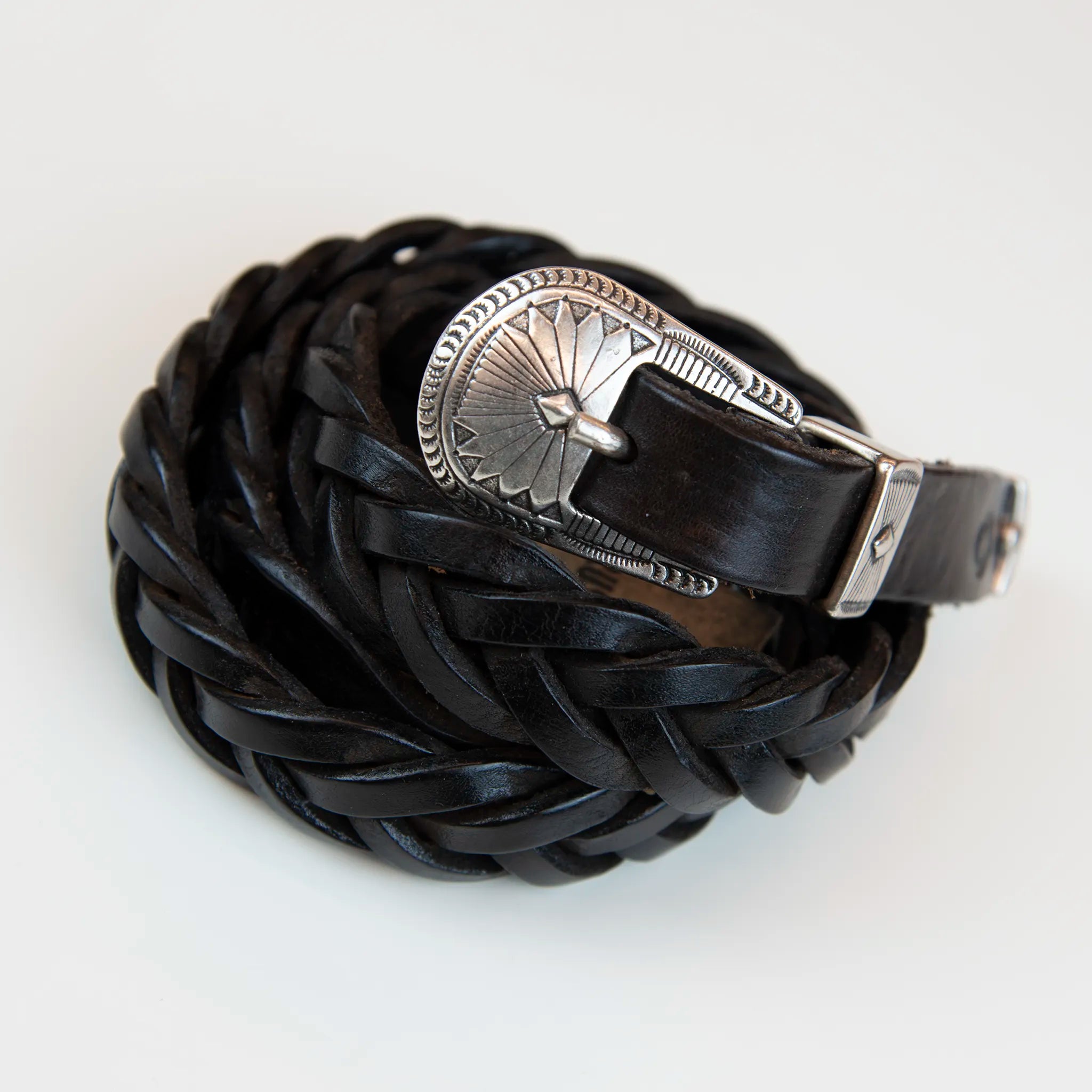 Cintura in pelle marrone intrecciata con fibbia intarsiata, realizzata con materiali di pregio, Made in Italy, progettata per garantire durata e resistenza nel tempo.