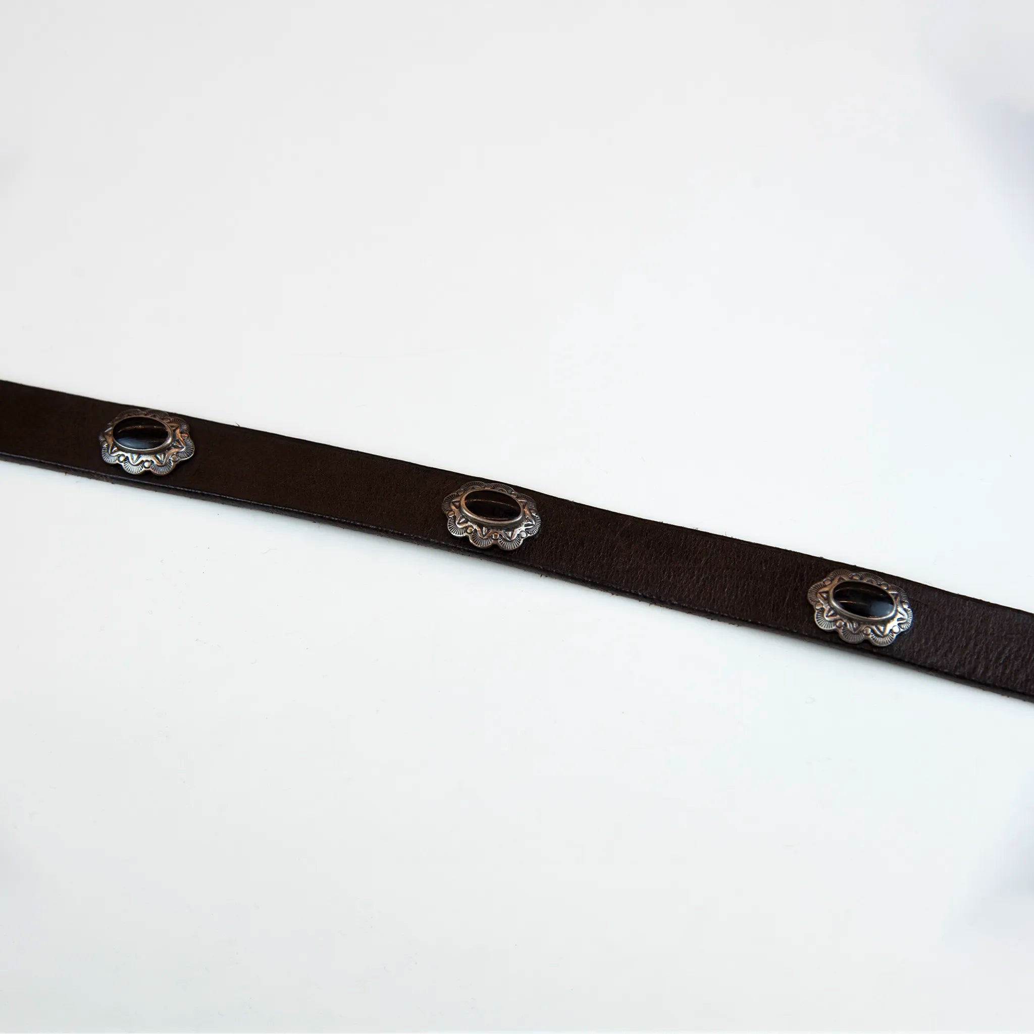 Cintura borchiata in pelle marrone con fibbia intarsiata, realizzata con materiali di alta qualità, Made in Italy, pensata per durare nel tempo.