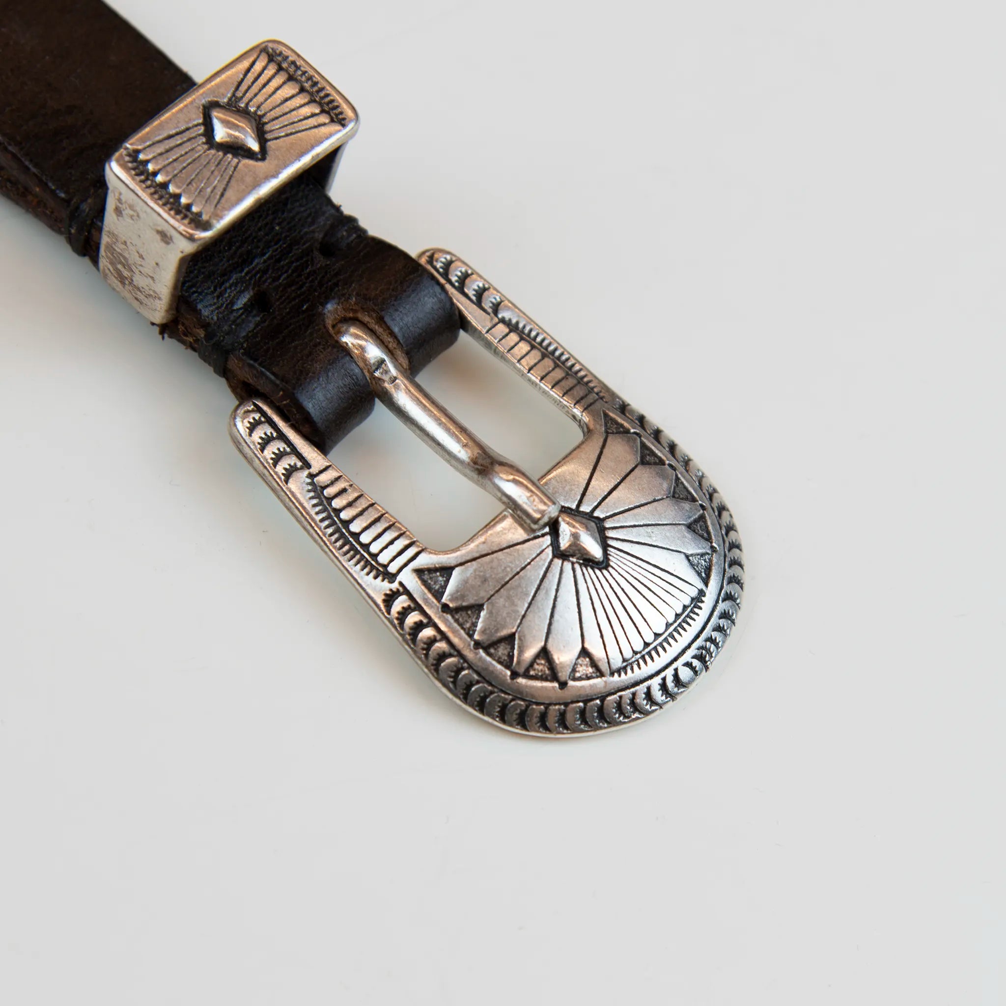 Fibbia intarsiata della Cintura borchiata in pelle marrone, realizzata con materiali di alta qualità, Made in Italy, pensata per durare nel tempo.