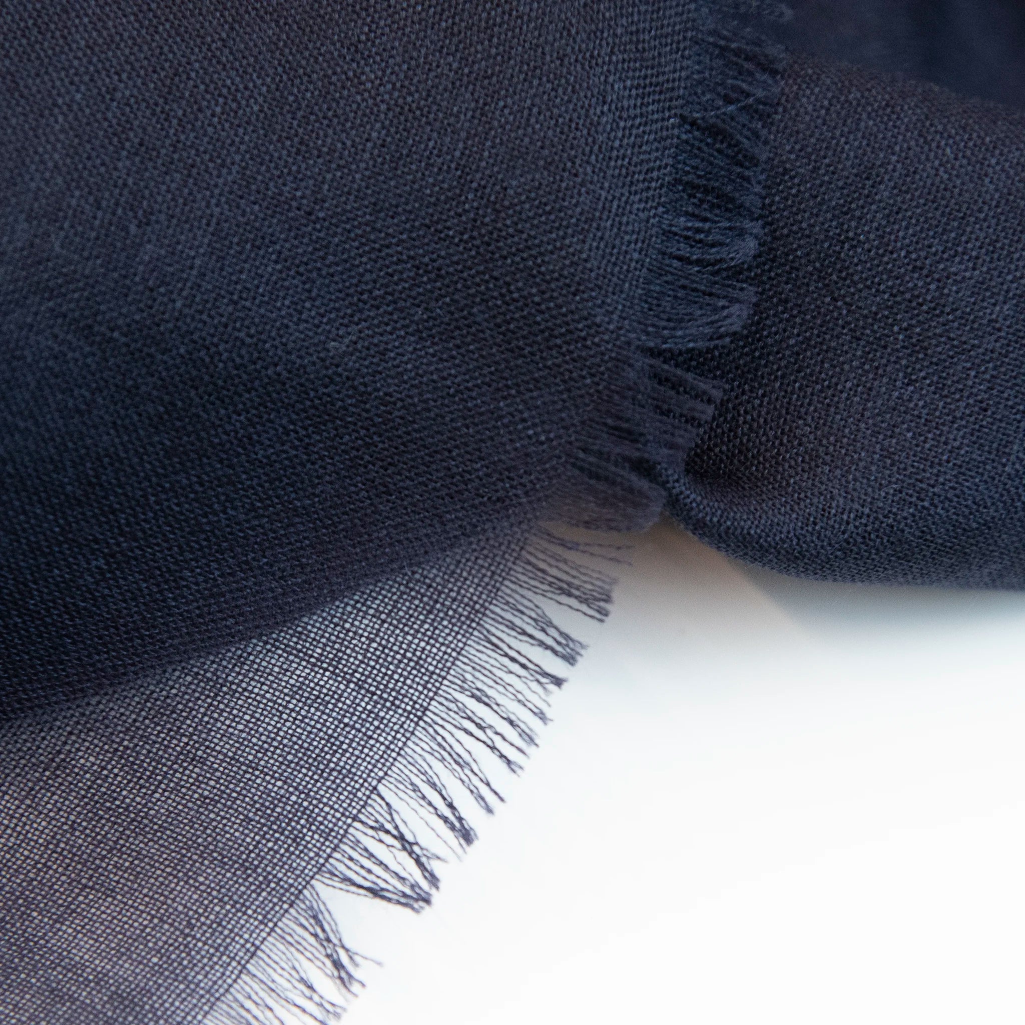 Dettagli e texture della Pashmina in 100% cashmere blu a tessitura twill, pregiata manifattura Made in Italy, sottile ed elegante adatta a ogni stagione.