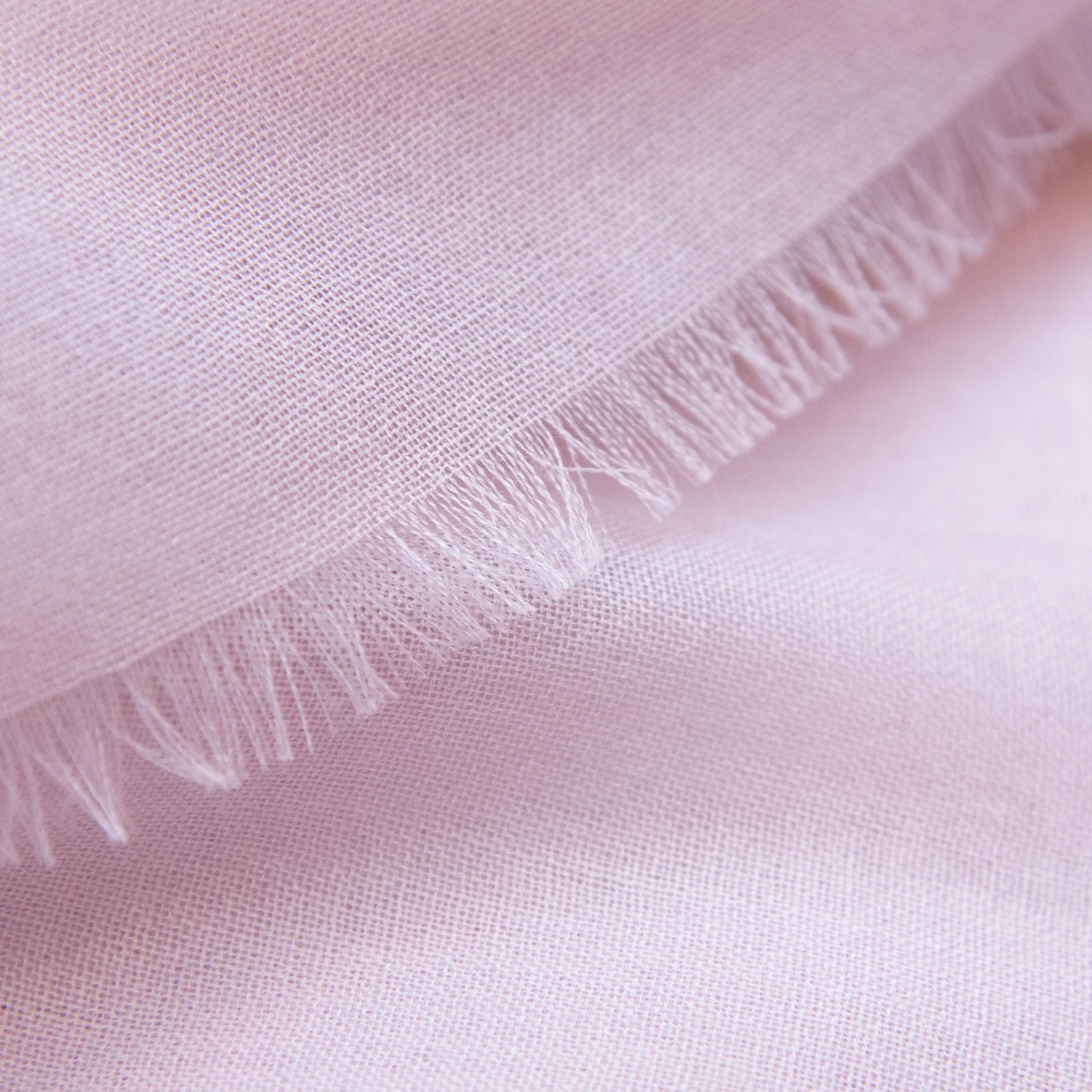 Dettagli e texture della Pashmina in 100% cashmere rosa a tessitura twill, pregiata manifattura Made in Italy, sottile ed elegante adatta a ogni stagione.