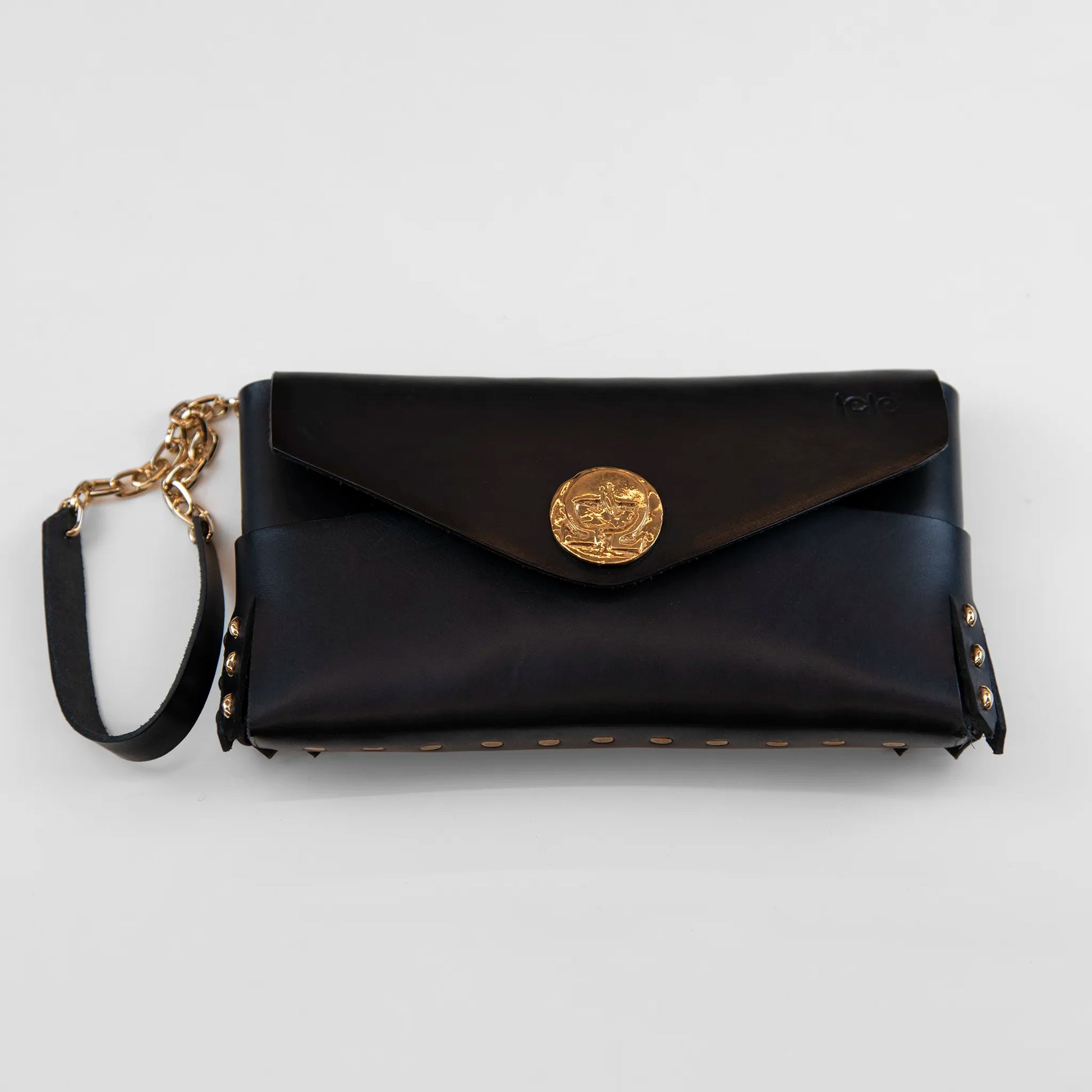 Portatutto in pelle nero borchiato con chiusura a calamita e polsiera per facile trasporto. Made in Italy, realizzato senza cuciture, secondo la tradizione degli antichi sellai Toscani, per maggiore robustezza e durata.