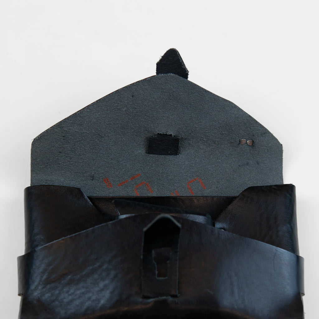Portatutto borchiato in pelle nera, Made in Italy, realizzato interamente a mano senza cuciture e bottoni, seguendo la tradizione degli antichi sellai Toscani per garantire maggiore robustezza e durata nel tempo.