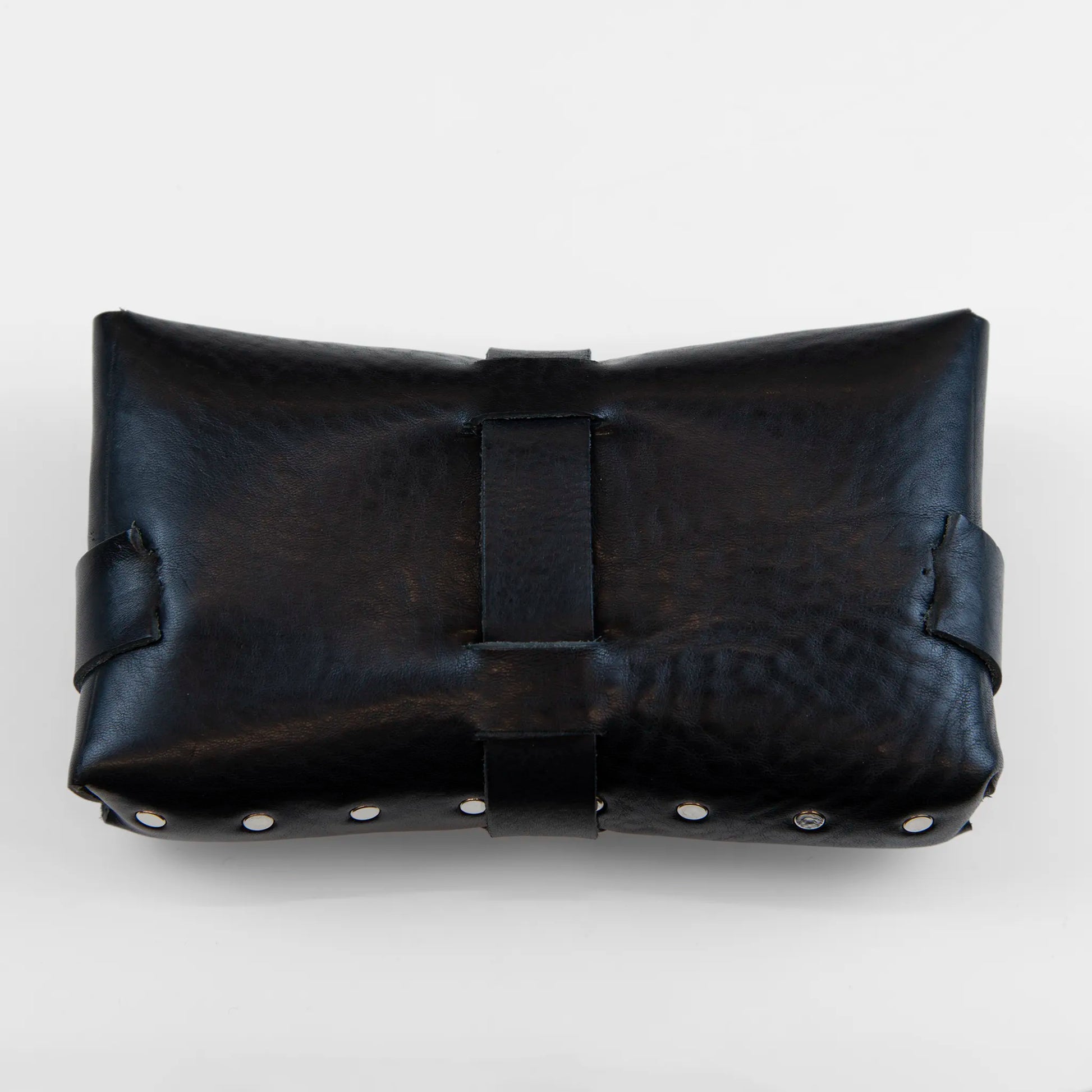Portatutto borchiato in pelle nera, Made in Italy, realizzato interamente a mano senza cuciture e bottoni, seguendo la tradizione degli antichi sellai Toscani per garantire maggiore robustezza e durata nel tempo.
