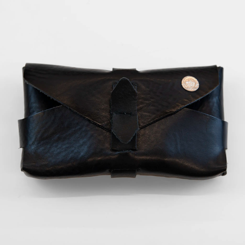 Portatutto borchiato in pelle nera, Made in Italy, realizzato interamente a mano senza cuciture e bottoni, seguendo la tradizione degli antichi sellai Toscani per garantire maggiore robustezza e durata nel tempo.