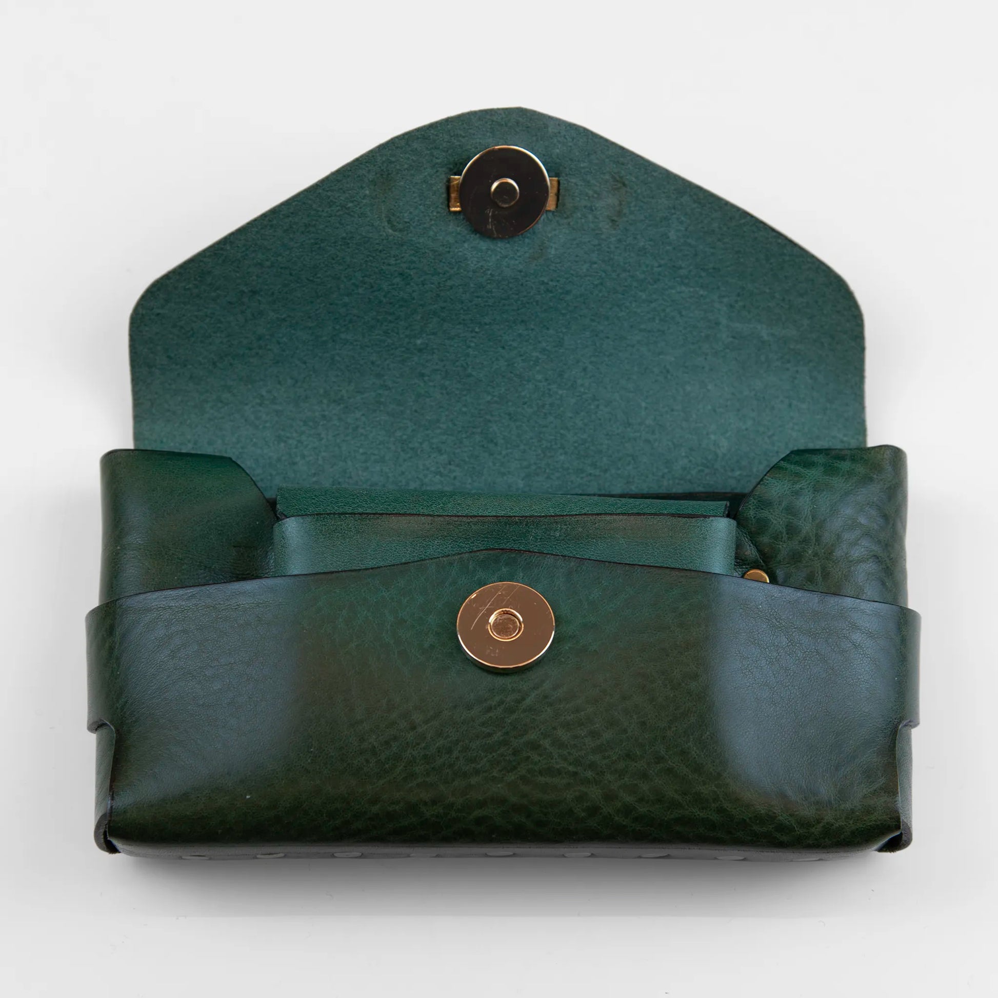 Portatutto borchiato in pelle verde con chiusura a calamita, Made in Italy, realizzato interamente a mano senza cuciture, secondo la tradizione degli antichi sellai Toscani, per garantire robustezza e durata nel tempo.