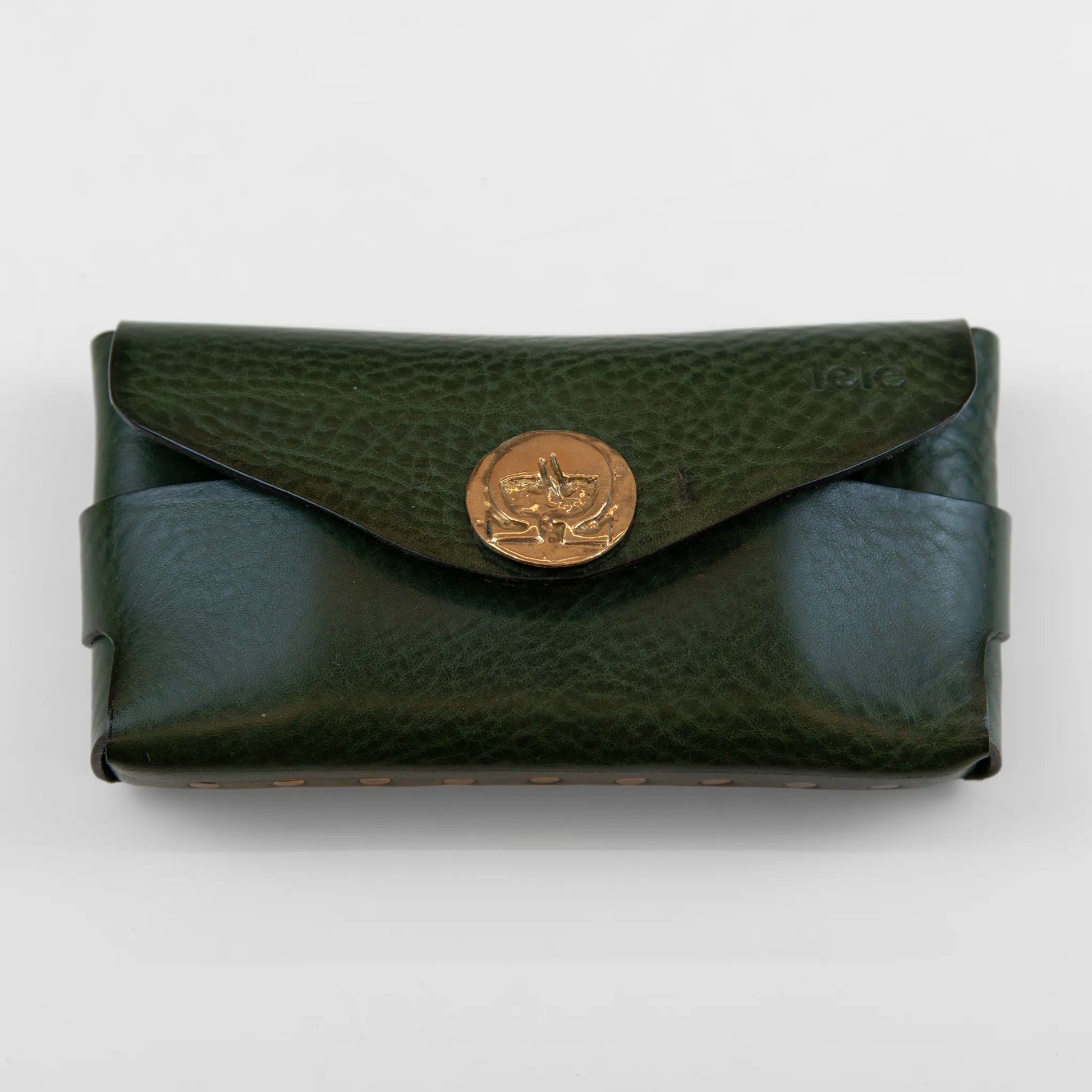 Portatutto borchiato in pelle verde con chiusura a calamita, Made in Italy, realizzato interamente a mano senza cuciture, secondo la tradizione degli antichi sellai Toscani, per garantire robustezza e durata nel tempo.