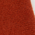 Dettaglio e texture tessuto del Collo in 100% cashmere color terracotta, versatile, utilizzabile come scaldacollo, fascia per capelli, passamontagna o cappello con sbuffo, Made in Italy, morbido e caldo.
