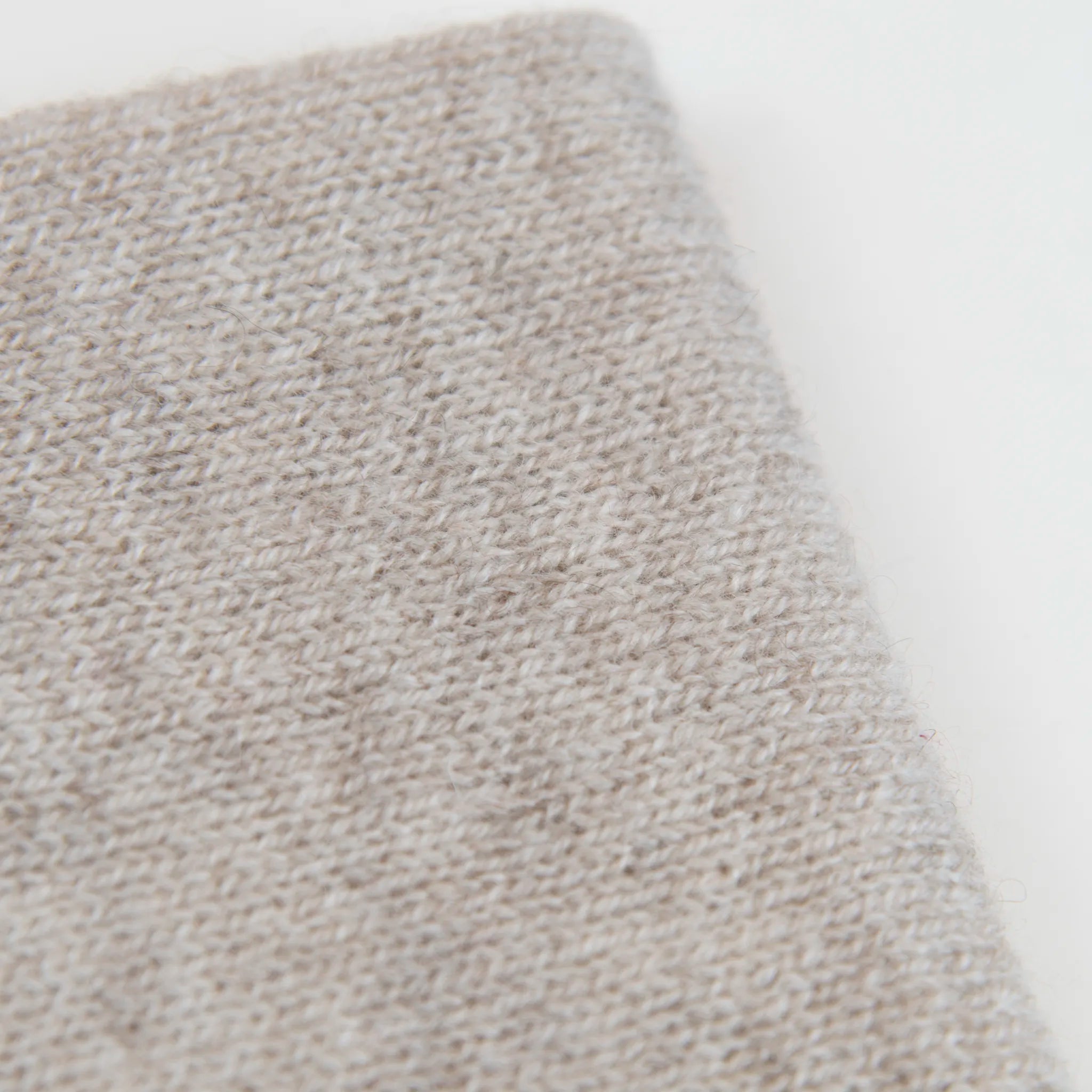 Dettaglio e texture tessuto del Collo in 100% cashmere color beige naturale, versatile, utilizzabile come scaldacollo, fascia per capelli, passamontagna o cappello con sbuffo, Made in Italy, morbido e caldo.