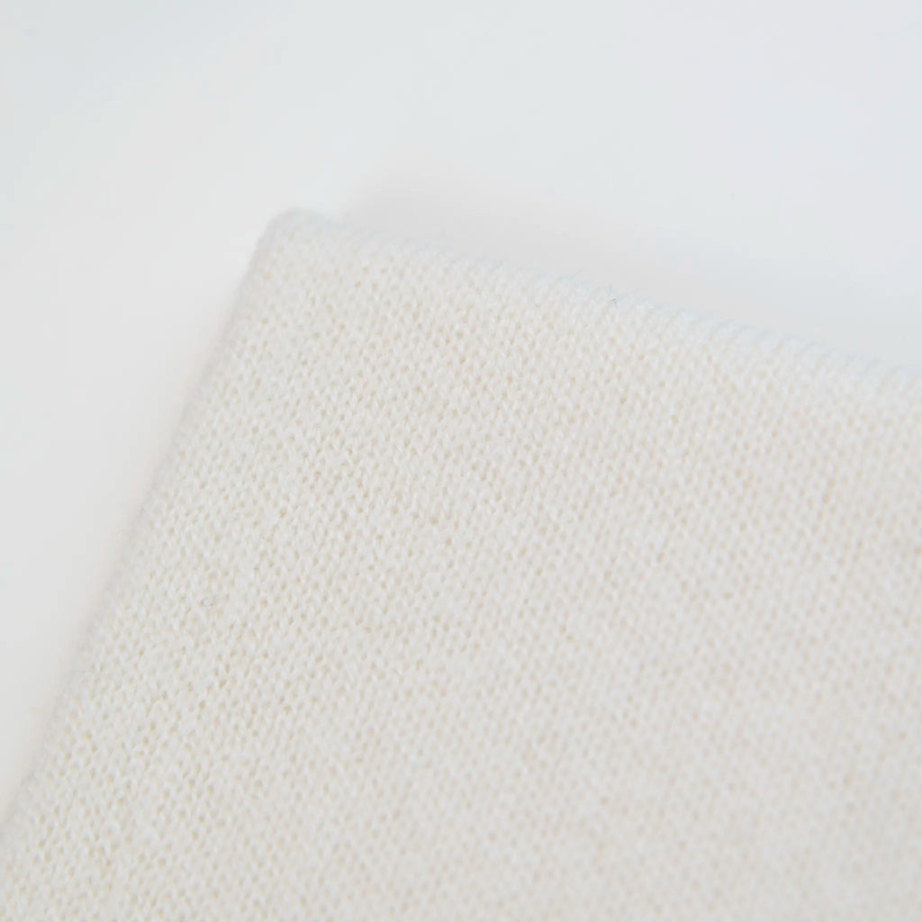 Dettaglio e texture tessuto del Collo in 100% cashmere panna, versatile, utilizzabile come scaldacollo, fascia per capelli, passamontagna o cappello con sbuffo, Made in Italy, morbido e caldo.