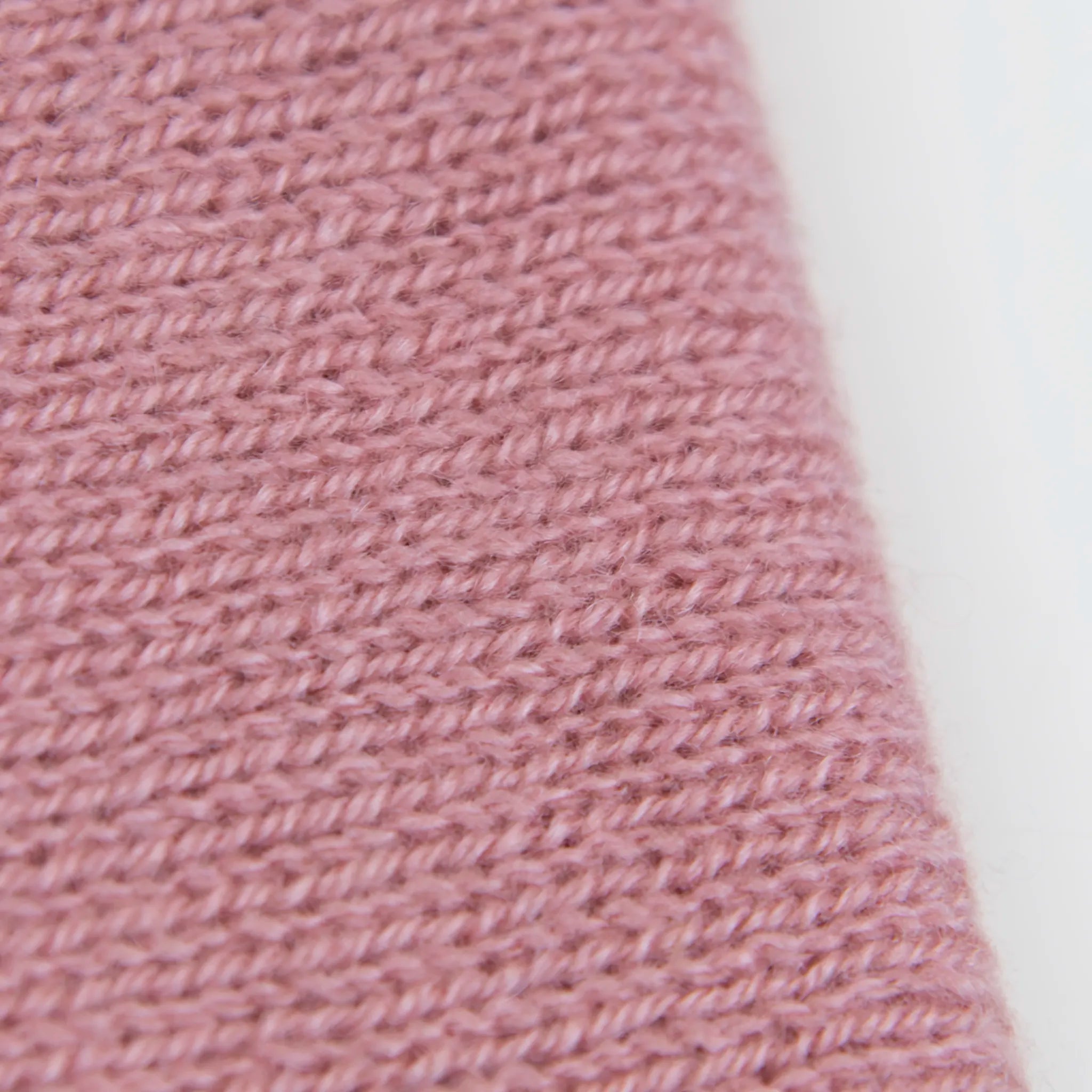 Dettaglio e texture tessuto del Collo in 100% cashmere rosa antico, versatile, utilizzabile come scaldacollo, fascia per capelli, passamontagna o cappello con sbuffo, Made in Italy, morbido e caldo.
